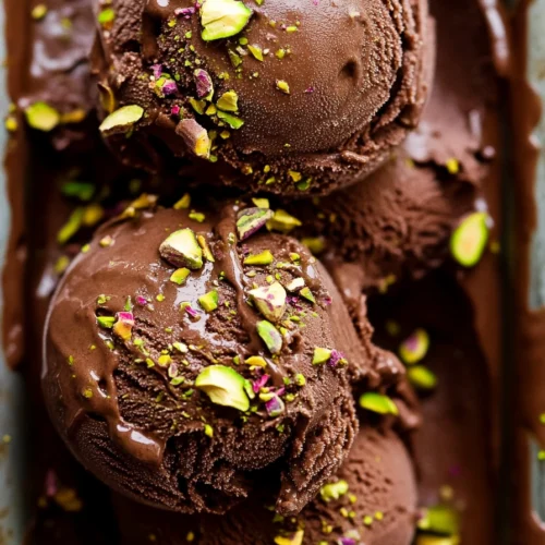Dubai Chocolate Ice Cream: A Decadent Treat You Can’t Miss 2 Scoops of creamy Dubai chocolate ice cream garnished with crushed pistachios in a tray.