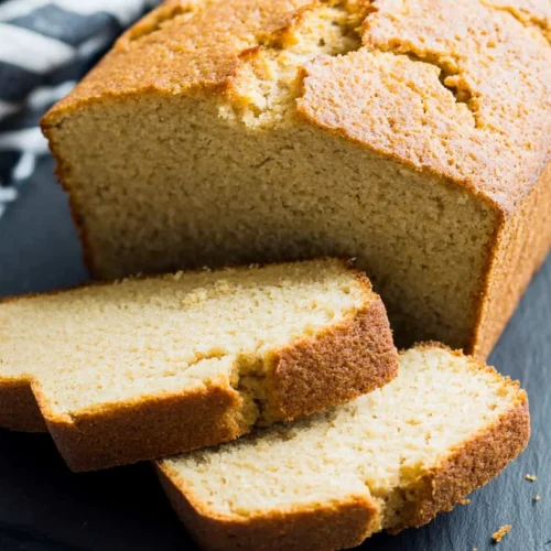 Paleo Bread: The Best Gluten-Free, Grain-Free Bread You Can Actually Toast 2 Sliced loaf of golden-brown paleo bread on a slate board with striped kitchen towels.